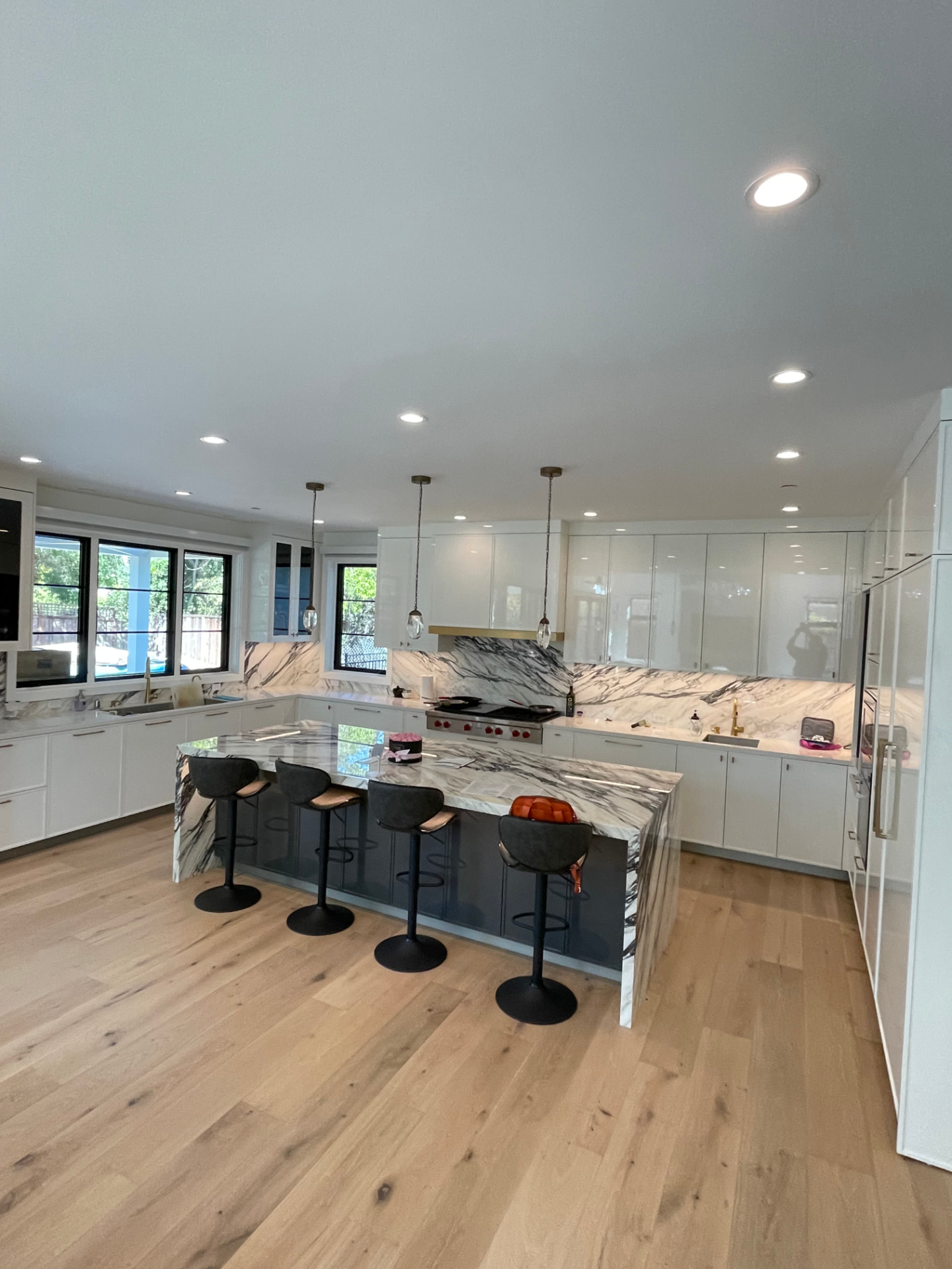 Modern high-gloss white kitchen with waterfall marble island