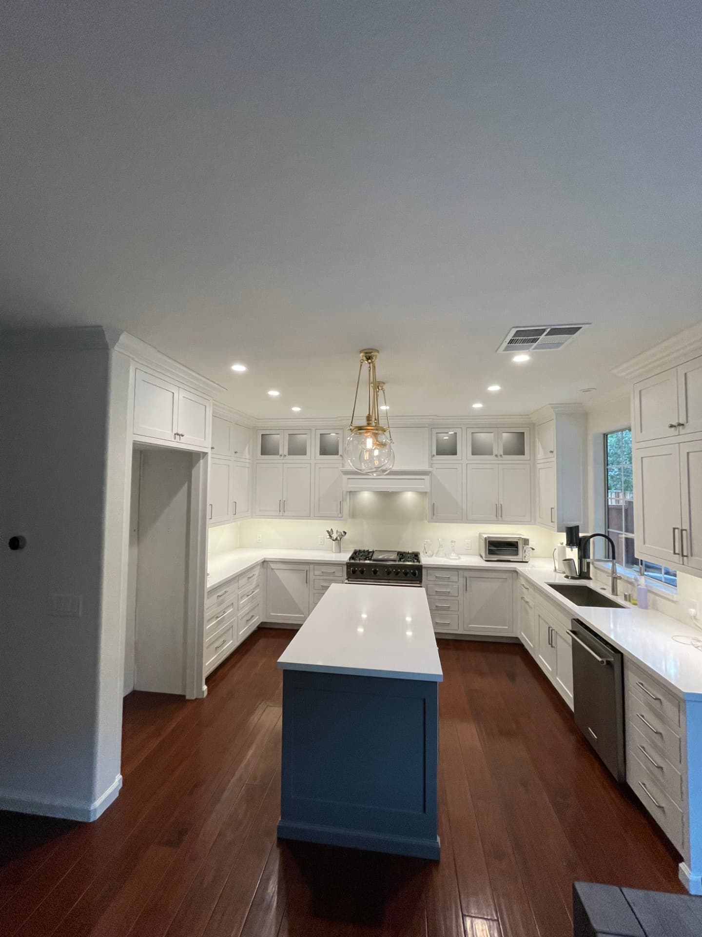 White custom cabinets with blue painted island