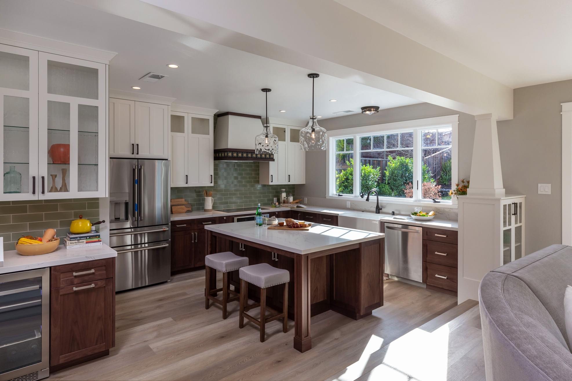 Two-tone kitchen remodel with green tile backsplash and walnut island