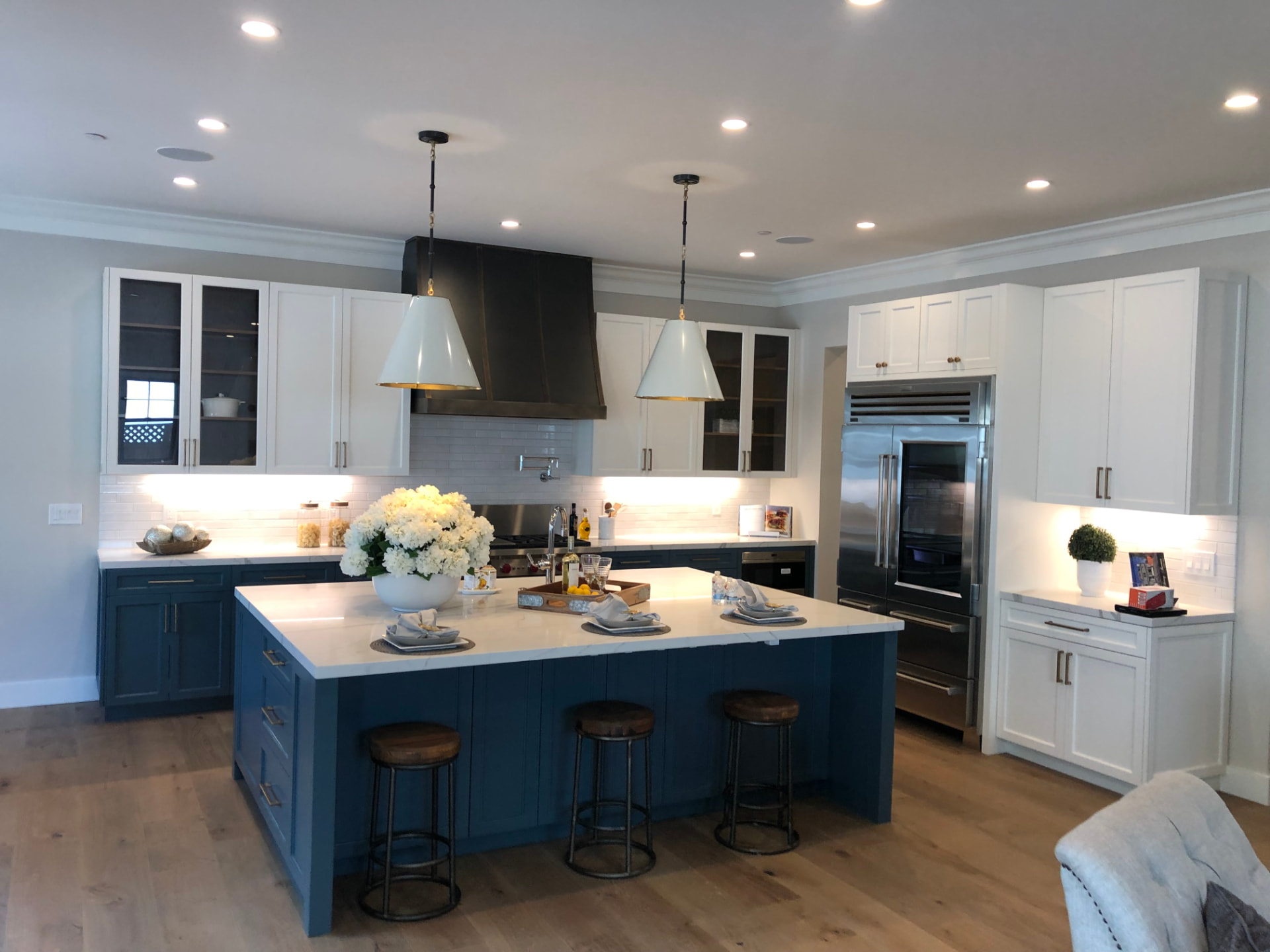 Navy island kitchen with white cabinetry and brass accents