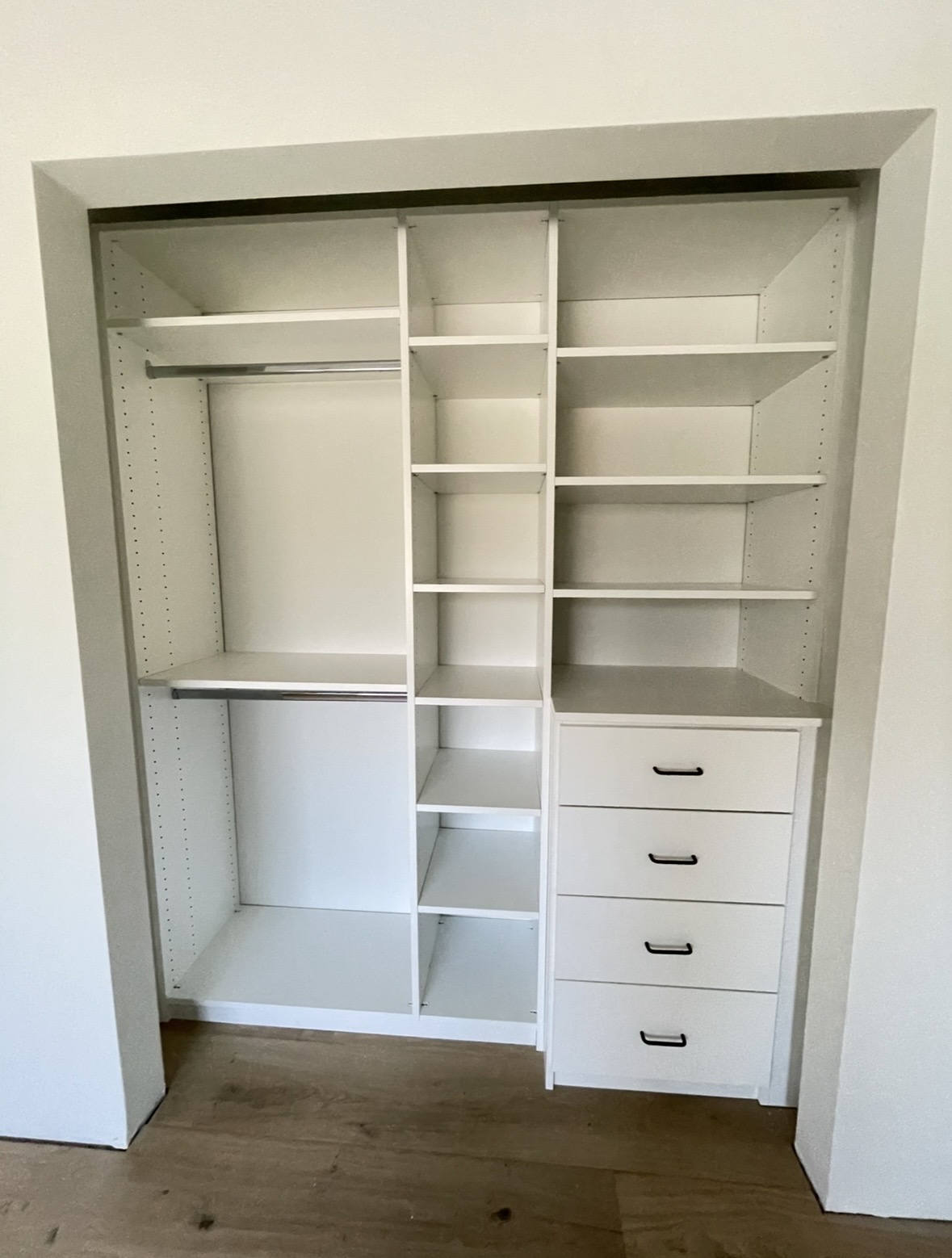 Reach-in closet with adjustable shelving and four-drawer unit